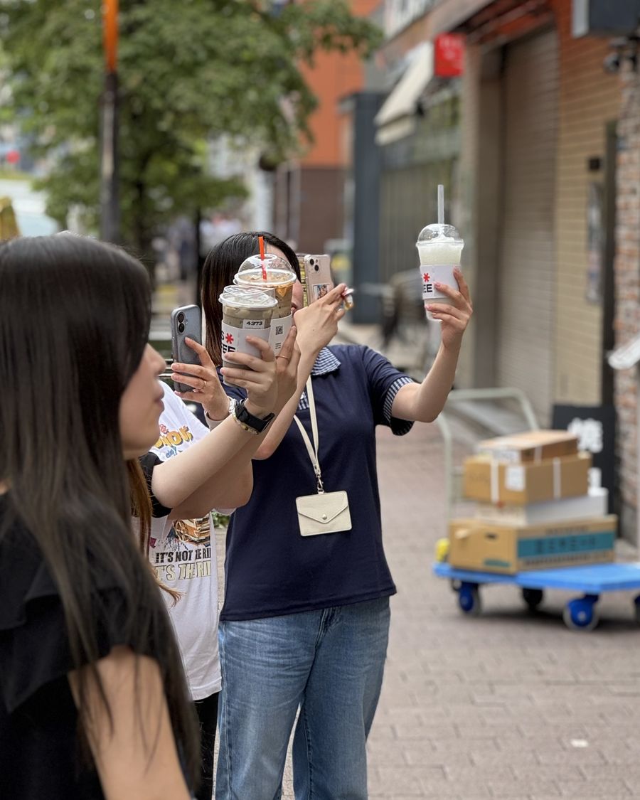 도쿄 신바시 거리에서 매스커피 음료를 든 손님들